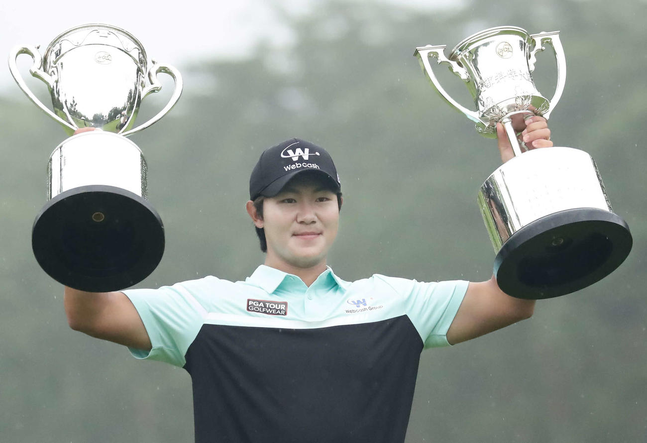 優勝杯と文部科学大臣杯を掲げるキム・ソンヒョン（撮影・丹羽敏通）