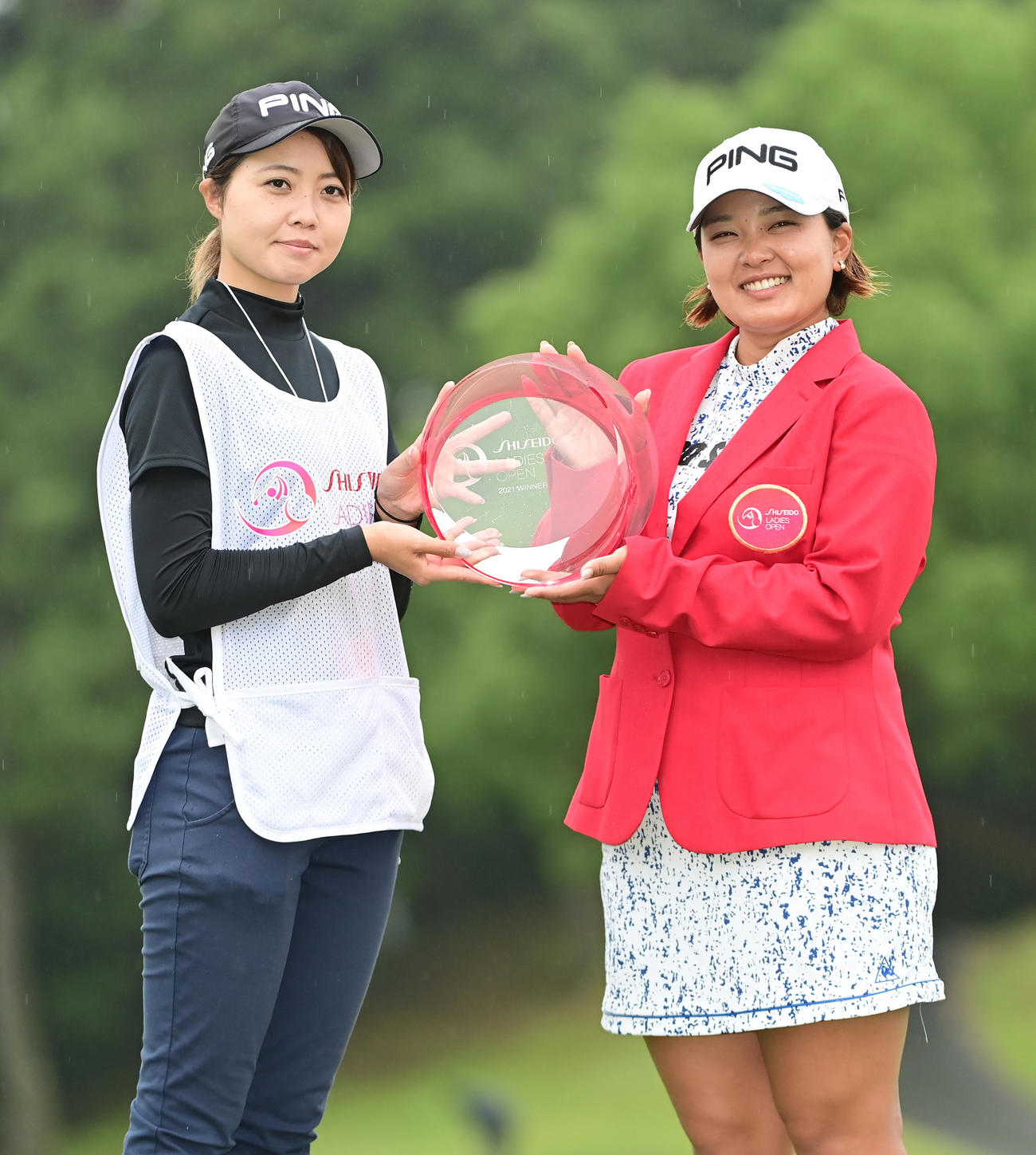 キャディーの飛田さん（左）と優勝杯を掲げる鈴木（撮影・小沢裕）