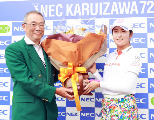 練習ラウンド後、NECの遠藤会長（左）から、五輪銀メダルのお祝いの花束を贈られ笑顔の稲見（撮影・浅見桂子）