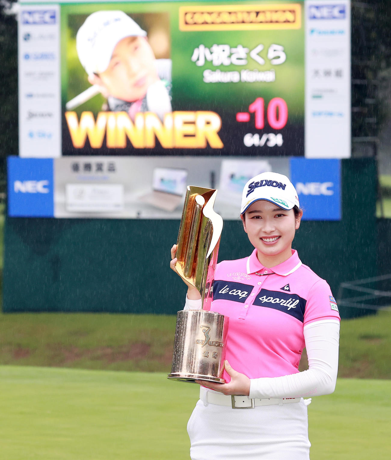 8月15日　NEC軽井沢72ゴルフトーナメント　掲示板を背にトロフィーを手に笑顔を見せる小祝さくら
