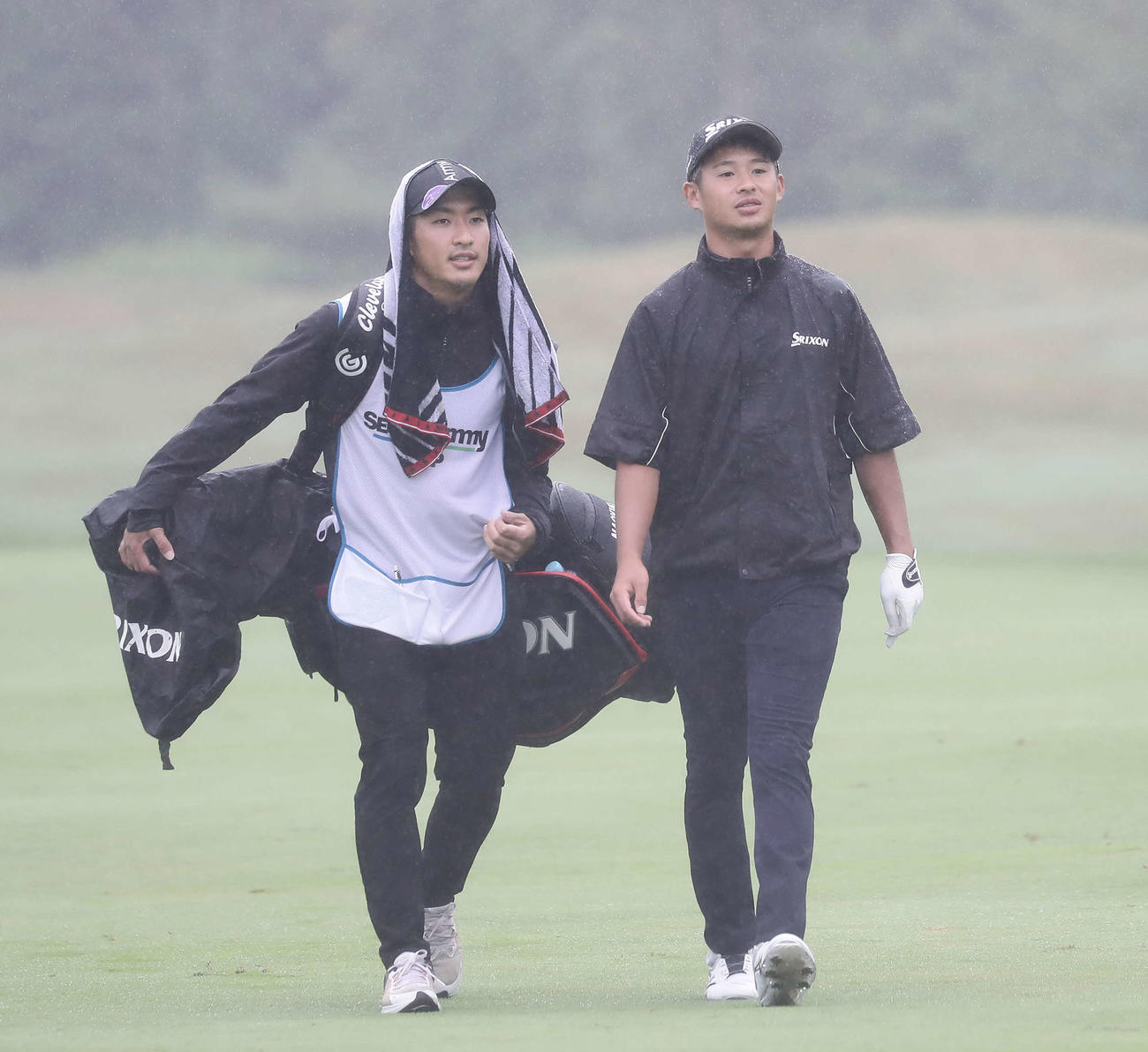 プロアマ戦で、雨の中ラウンドする片岡（右）とキャディーの笹村（撮影・丹羽敏通）