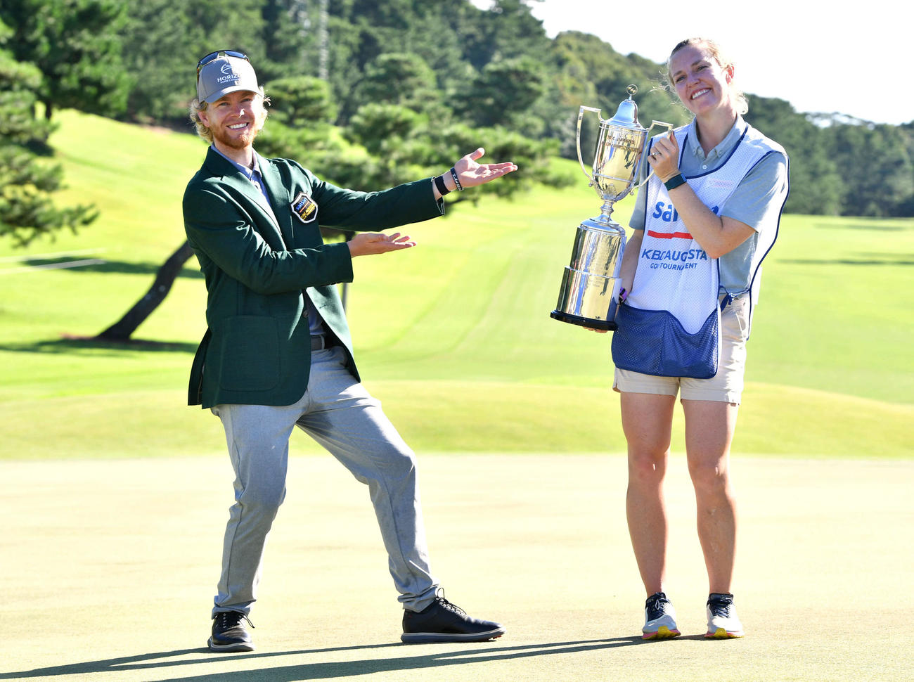 キャディーを務めた妻ケルシーさん（右）に感謝するように、優勝杯を渡して笑顔でポーズをとるビンセント（撮影・岩下翔太）