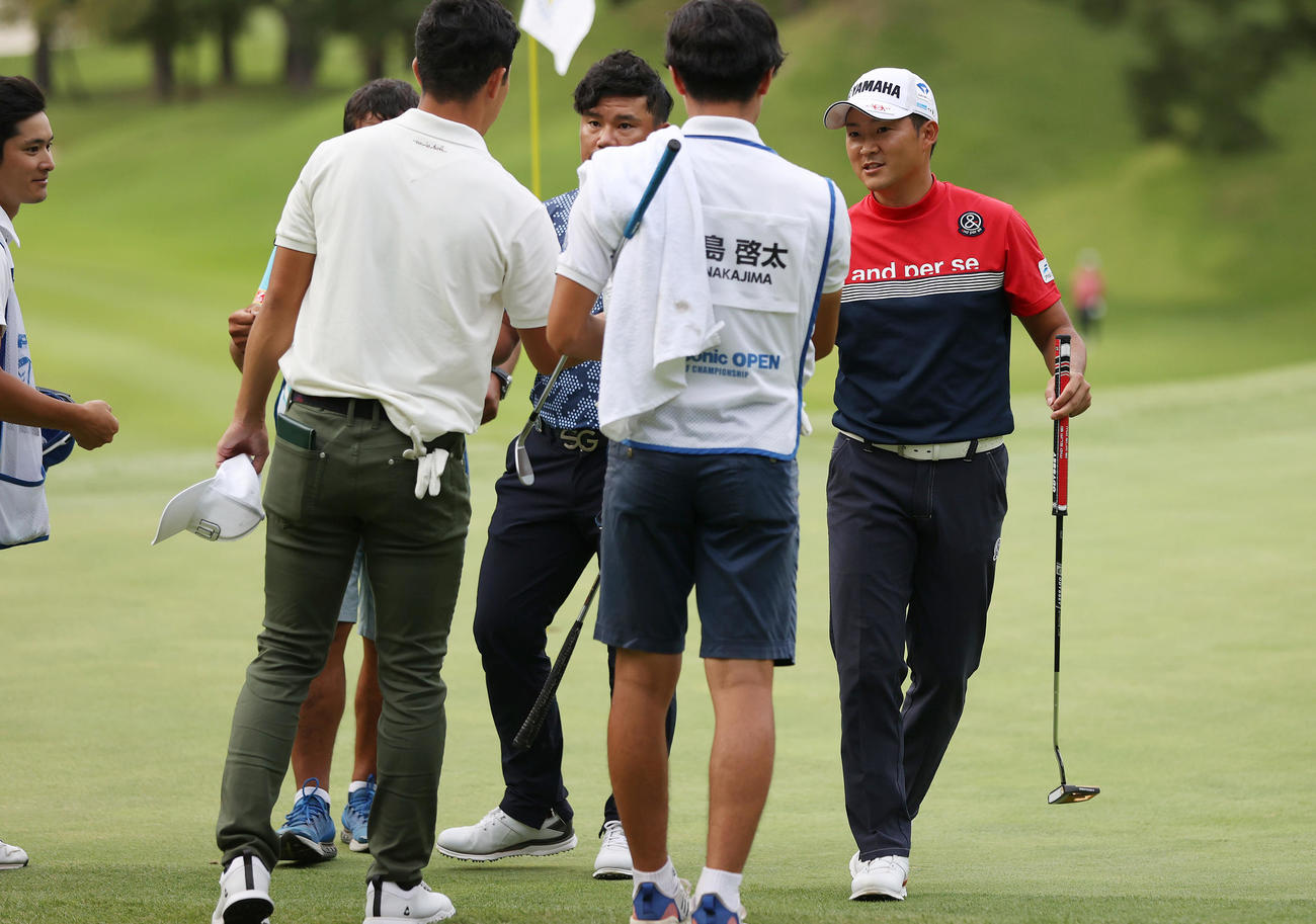 18番、同組の選手らとグータッチを交わしホールアウトする今平周吾（右端）（撮影・前田充）