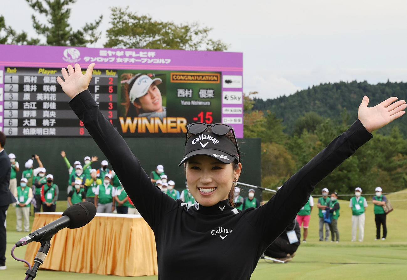 15アンダーの大会記録で優勝した西村は記録を背に笑顔でバンザイ（撮影・河野匠）