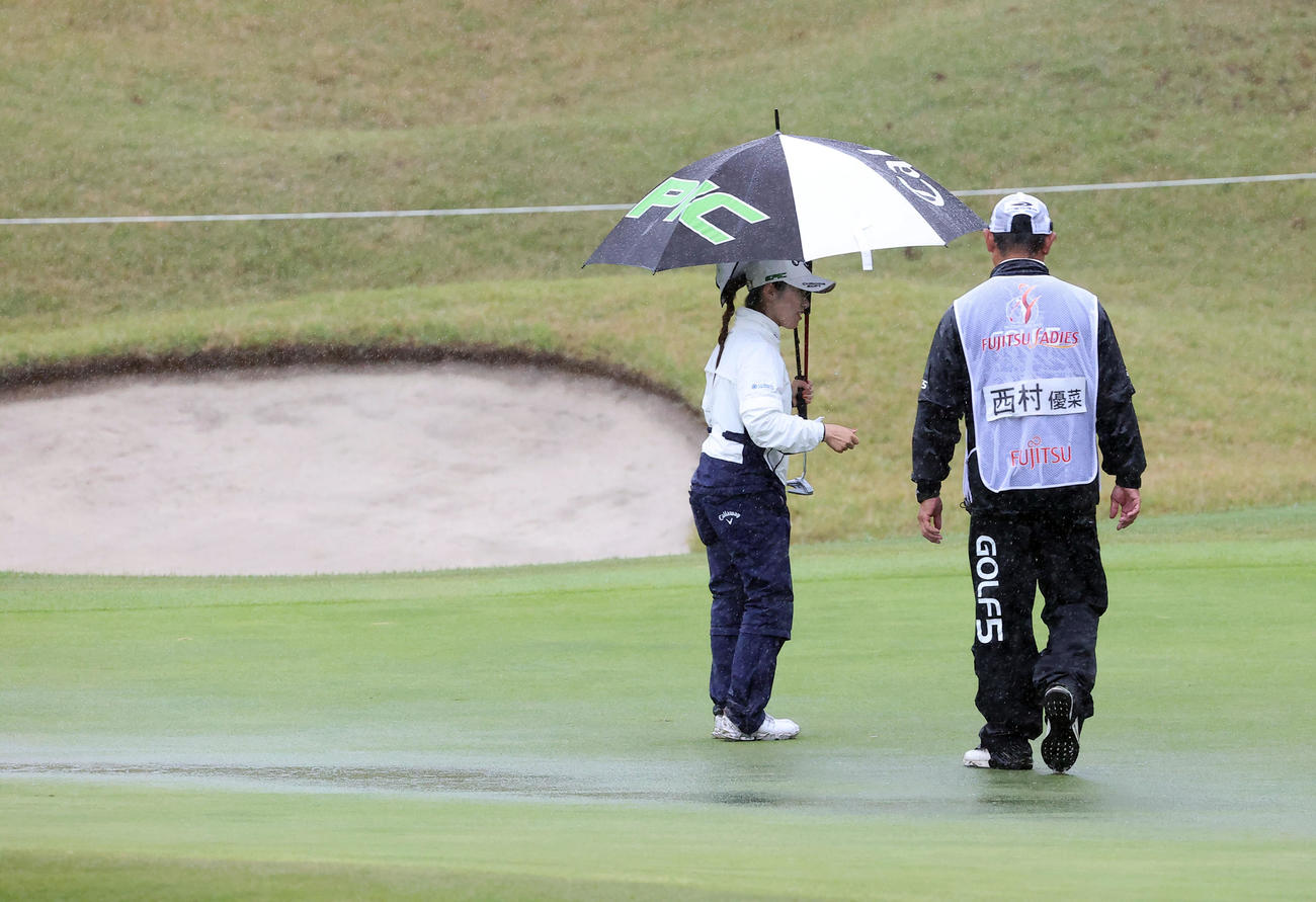 雨が強まり、1番グリーンにも水たまりが出来て中断となる。選手は西村（撮影・浅見桂子）