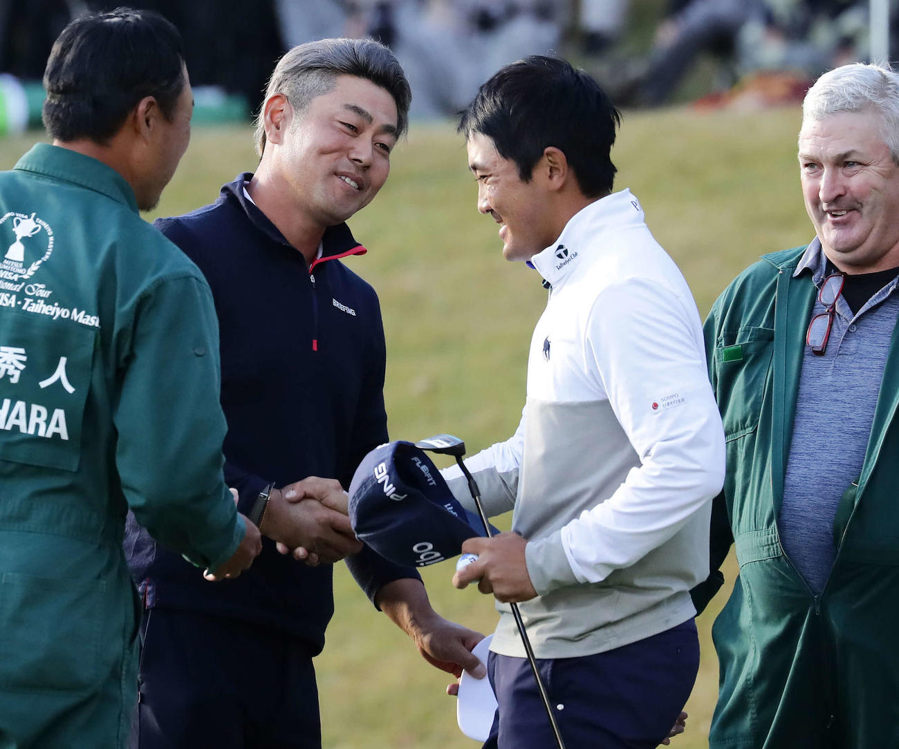 18番、最後まで優勝を争った“教え子”の金谷（右）と握手する谷原（撮影・丹羽敏通）