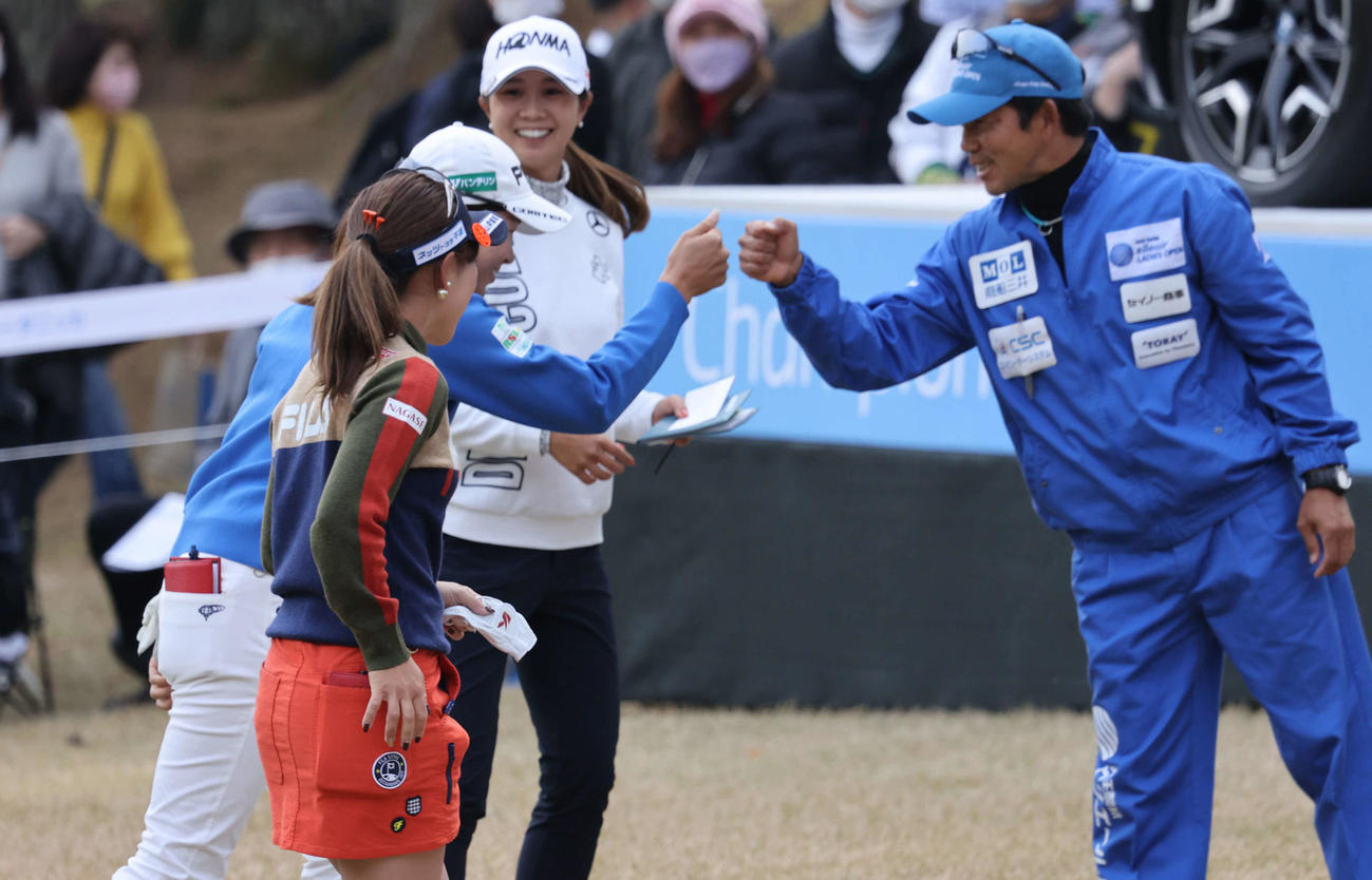 18番、ホールアウトしキャディーとグータッチする渋野（撮影・加藤孝規）
