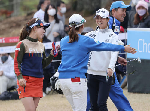 18番、ホールアウトし同組の選手と抱擁する渋野（中央）（撮影・加藤孝規）