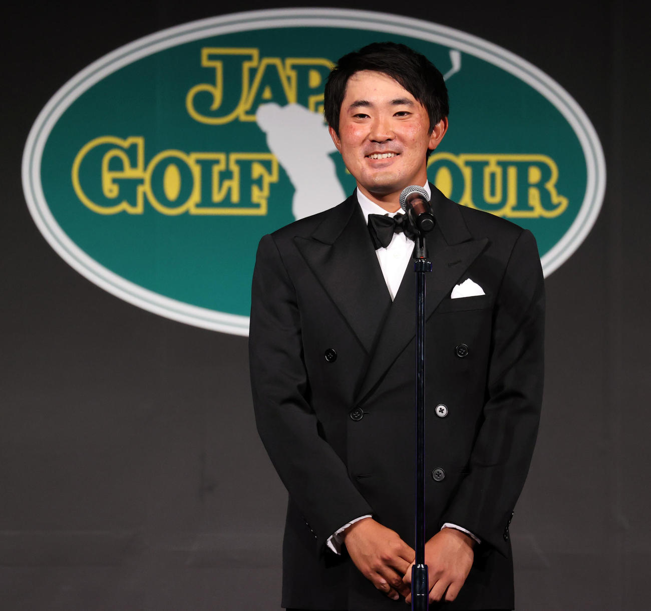 ジャパンゴルフツアー表彰式で最優秀新人賞等計4つの賞を受賞した金谷は笑顔であいさつする（撮影・浅見桂子）