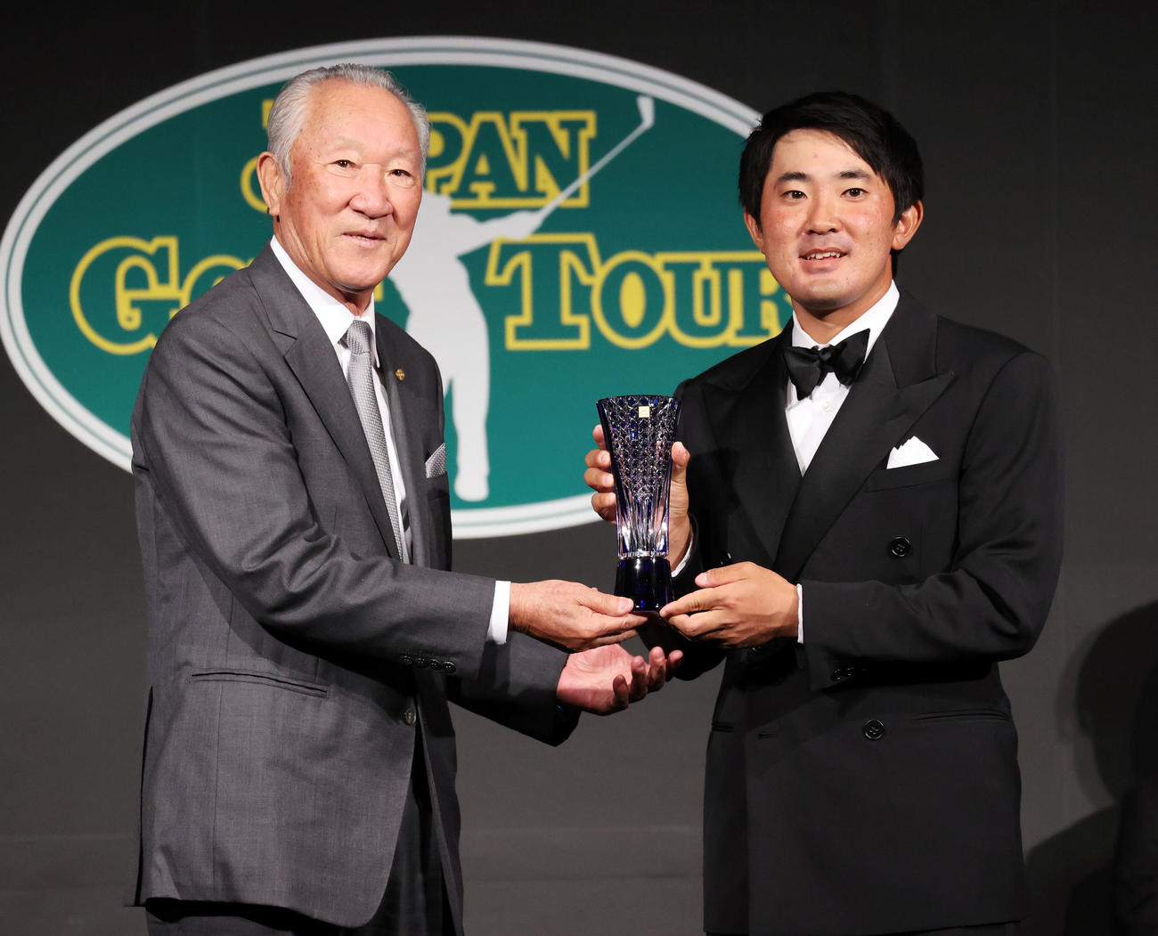 ジャパンゴルフツアー表彰式で最優秀新人賞を受賞した金谷（右）はトロフィーを手に青木会長と記念撮影（撮影・浅見桂子）