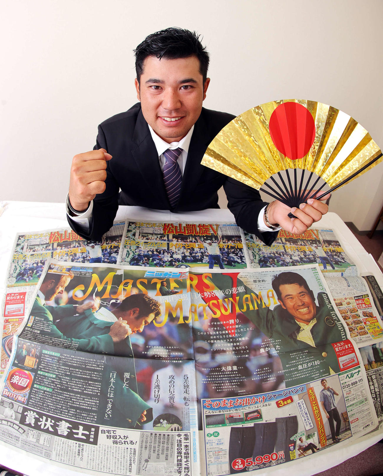 1年を振り返り、今後についての思いを語った松山は、広げられたマスターズ優勝の紙面を前に笑顔でガッツポーズ（撮影・浅見桂子）