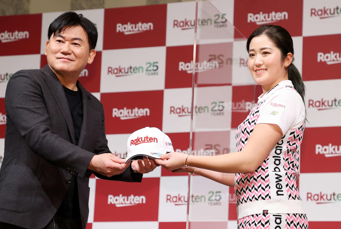 三木谷会長兼社長（左）から楽天ロゴ入りキャップを受け取る稲見（撮影・鈴木正人）