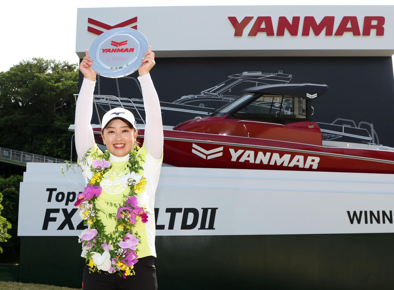 トータル10アンダーでプロ初優勝を決め副賞のボートの前でバンザイする西郷（撮影・加藤哉）
