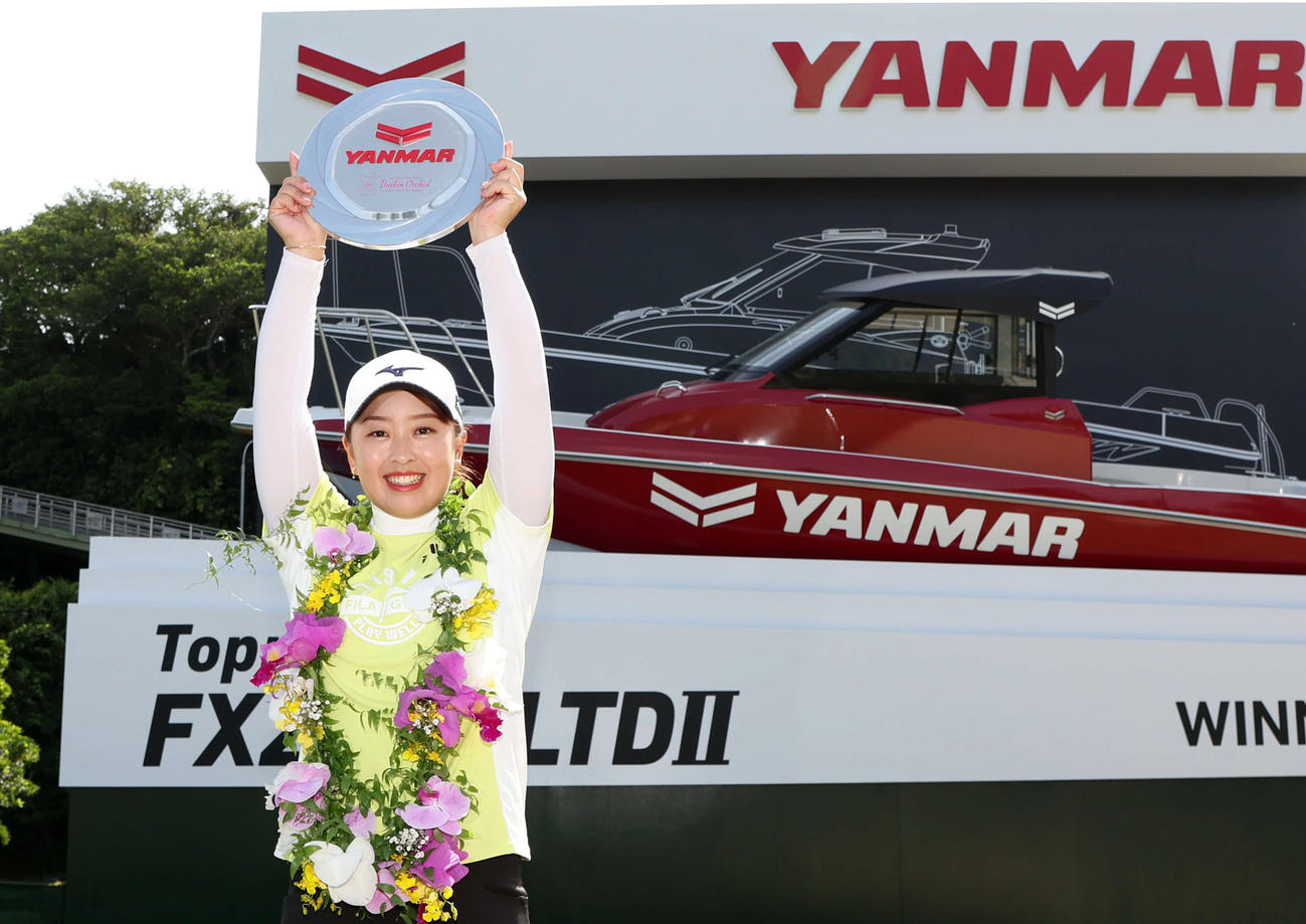 プロ初優勝を決めた西郷真央は副賞のボートの前でバンザイ（撮影・加藤哉）