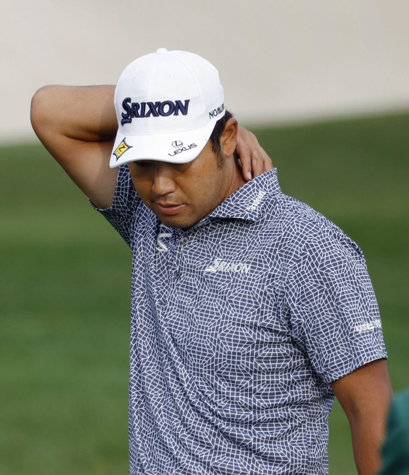 練習場で調整中、首元に手をやる松山英樹＝オーガスタ・ナショナルGC（共同）