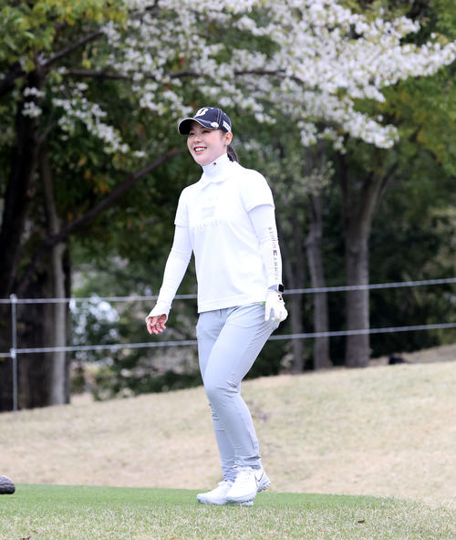 1番、ティーショットを放ち、桜を背に笑顔で歩き出す吉田優利（撮影・浅見桂子）