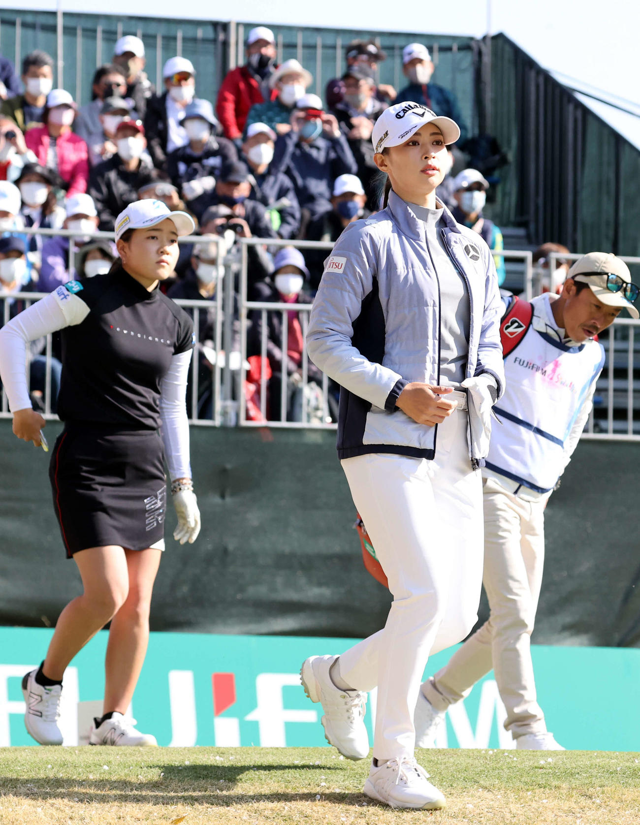 1番、ティーショットを終えて歩き出す柏原（手前）。左は佐藤（撮影・浅見桂子）