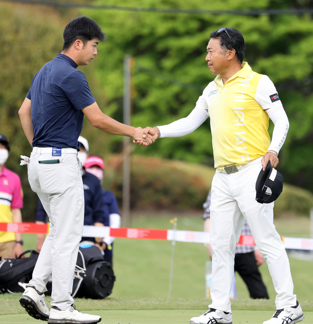 ホールアウトし細野（左）と握手する片山（撮影・鈴木正人）