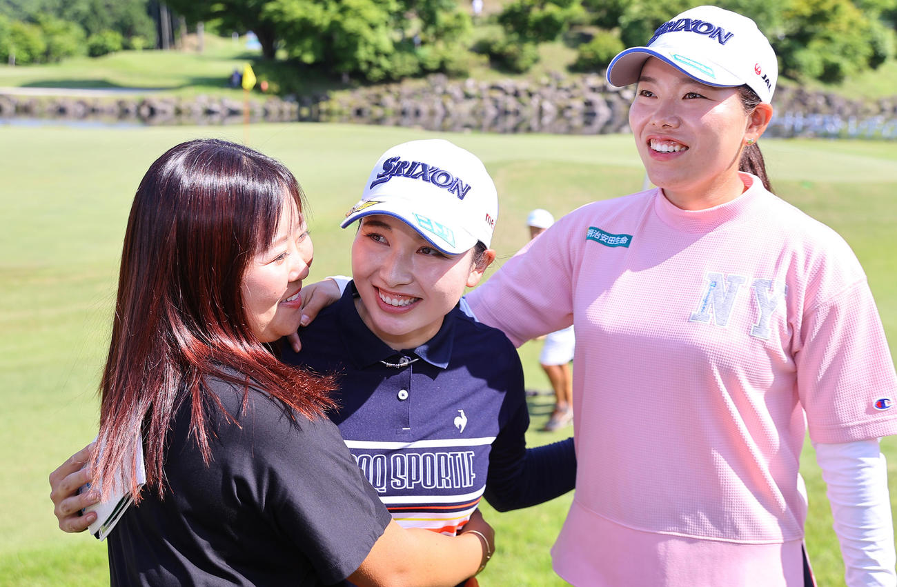 優勝を決めた小祝（中央）は勝（右）、浅井（左）らから祝福され笑顔を見せる（撮影・垰建太）