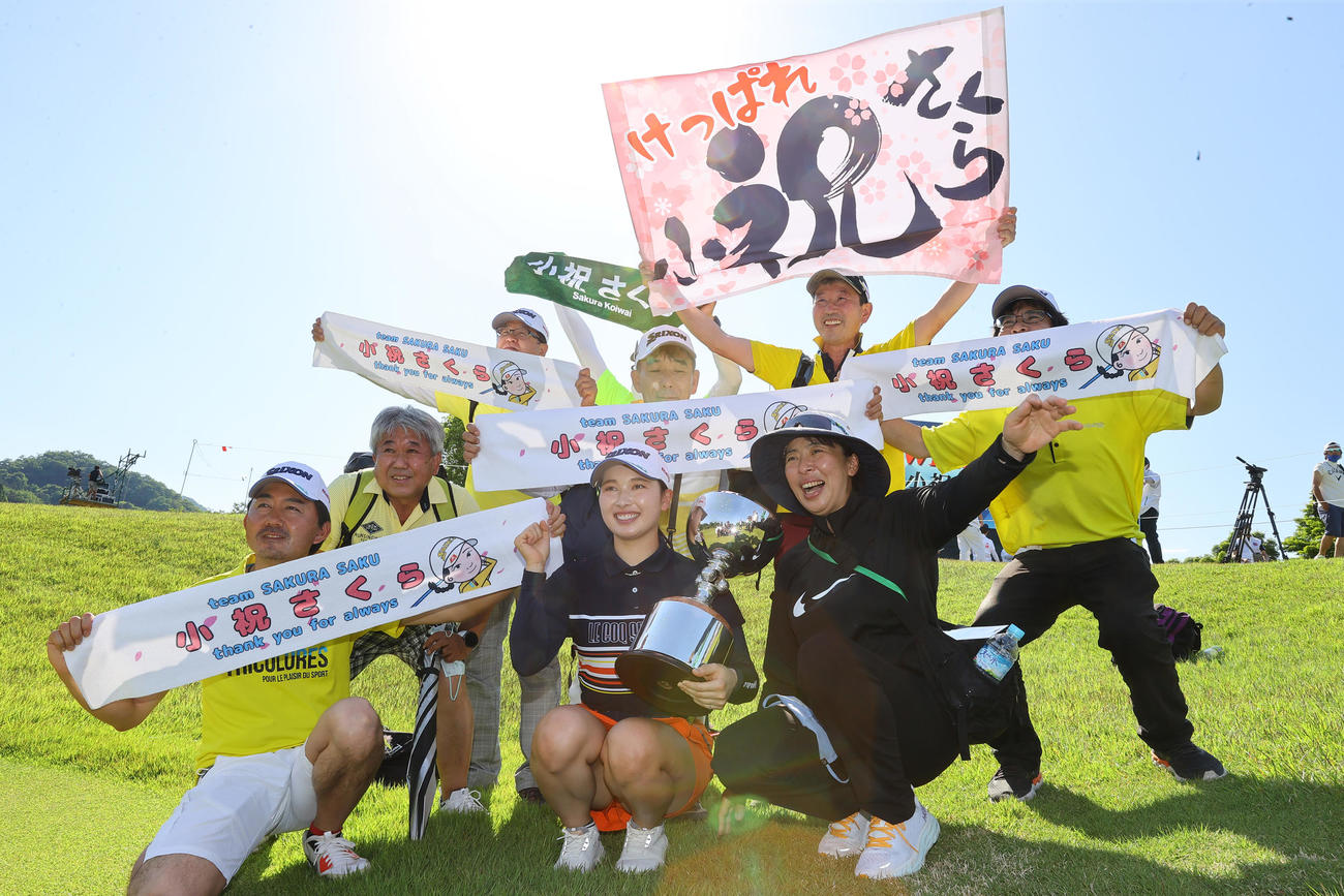 優勝を決めた小祝（前列中央）は母ひとみさん（同右）ら関係者と笑顔で写真に納まる（撮影・垰建太）