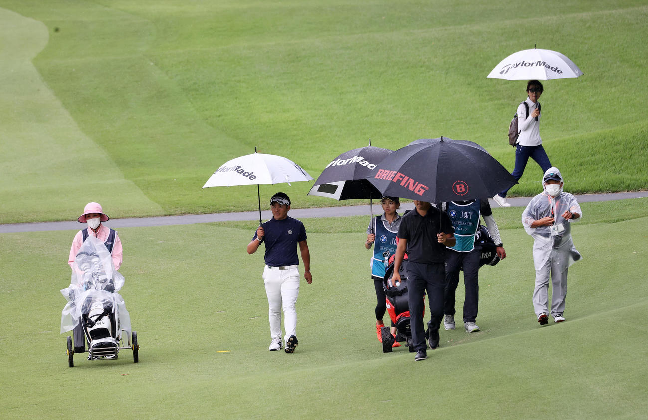 雷雲接近で中断になりグラブハウスに引き揚げる選手たち（撮影・鈴木正人）