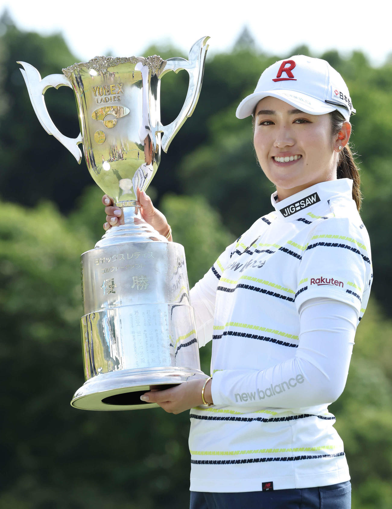 優勝トロフィーを掲げる稲見（撮影・丹羽敏通）