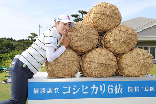 優勝し副賞の米俵と写真に納まる稲見（撮影・丹羽敏通）