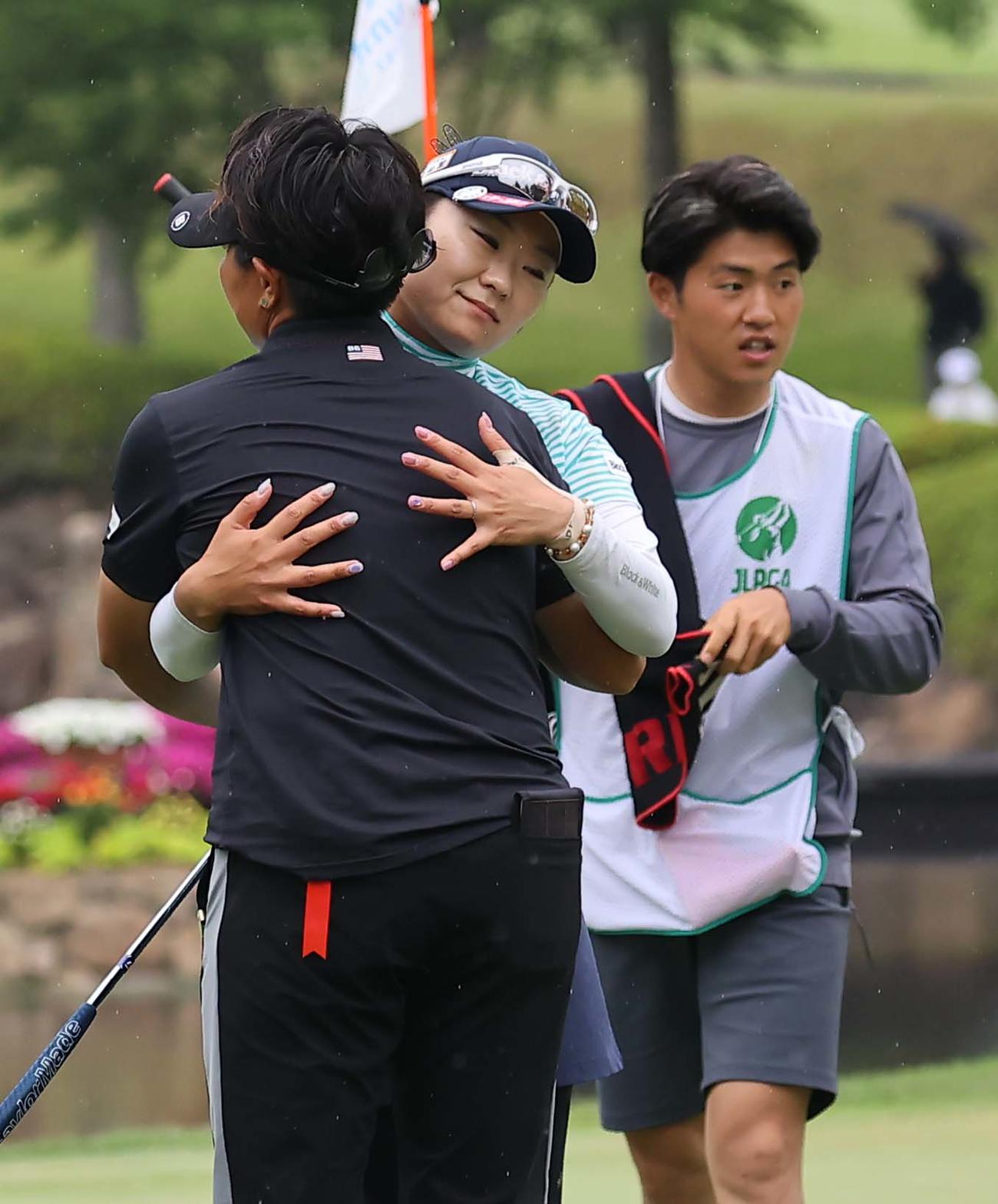 18番、ホールアウトし工藤（左）と抱き合って健闘を称え合う藤田（撮影・上田博志）