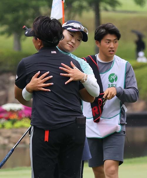 18番、ホールアウトし工藤（左）と抱き合って健闘を称え合う藤田（撮影・上田博志）