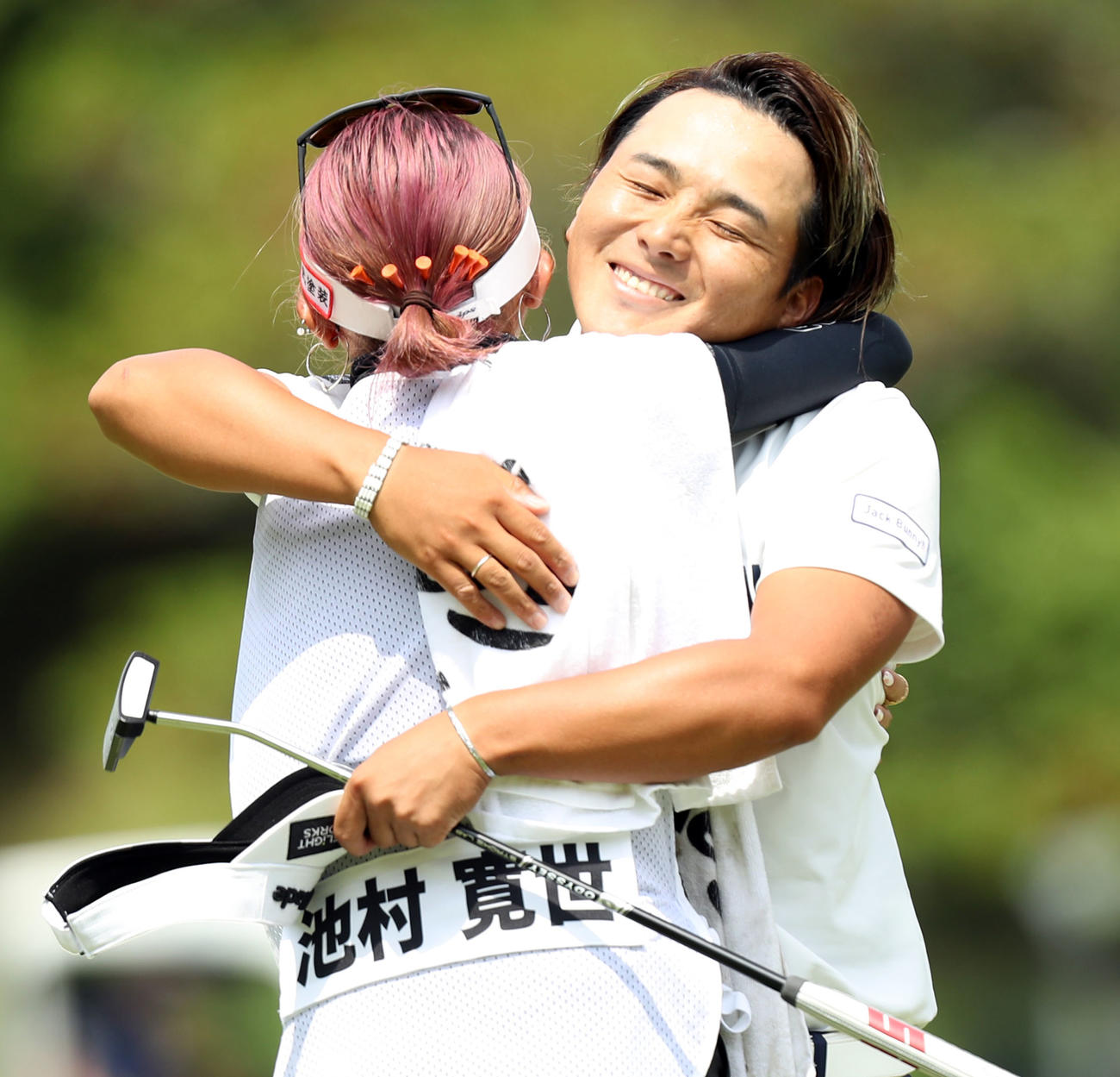 優勝を決め、キャディーを務めた恋人の坂口琴音さん（左）と抱き合う池村（撮影・屋方直哉）