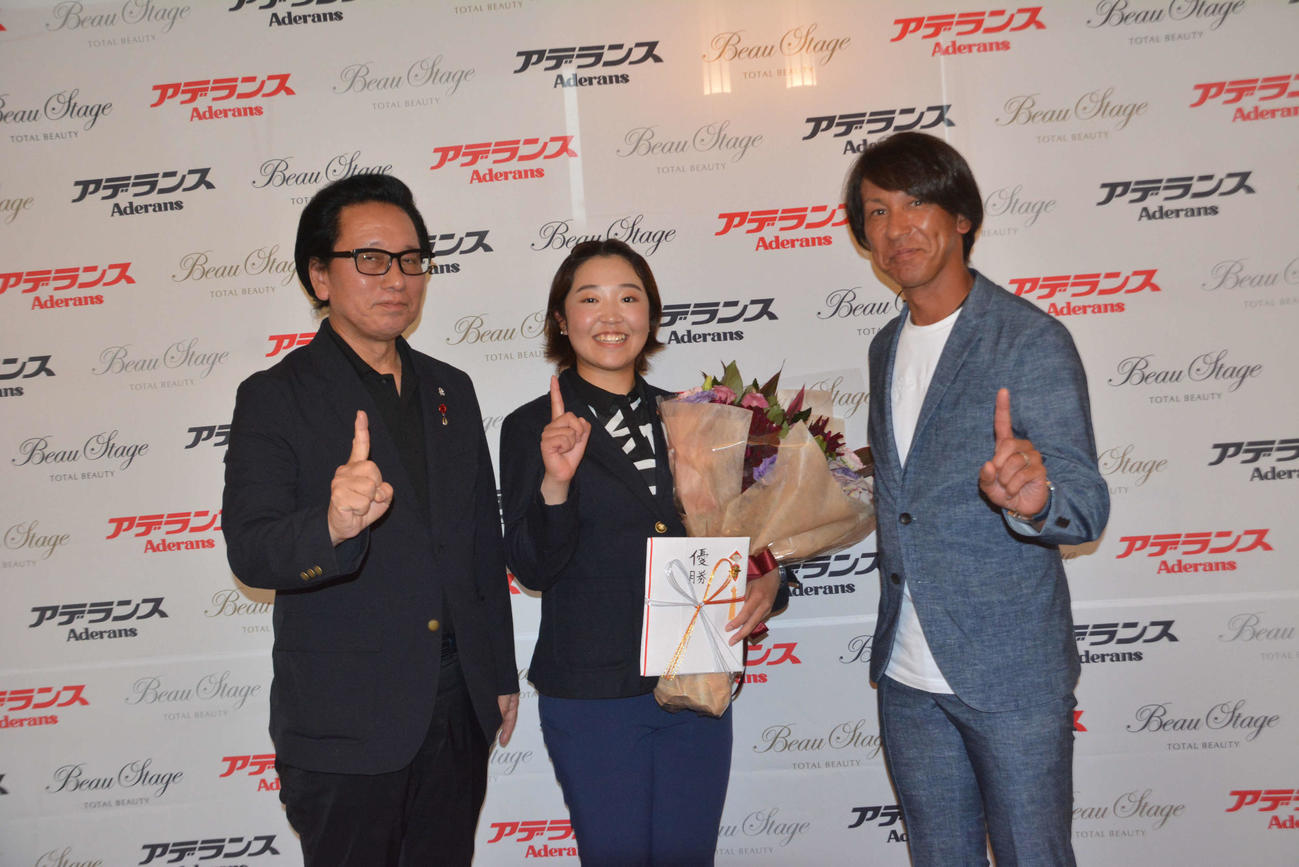 優勝した小林芽以（中央）を祝福するアデランス社の津村佳宏社長（左）と葛西紀明