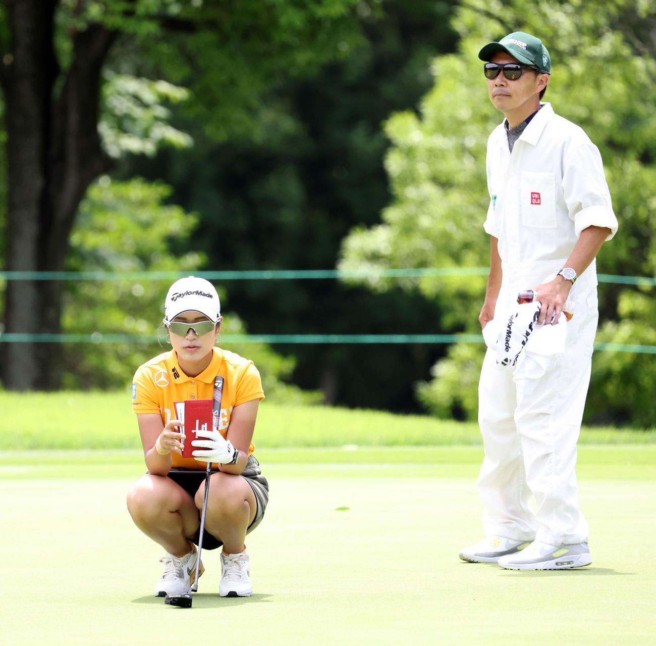 第2日、1番のグリーンでラインを読む大西とキャディー（撮影・浅見桂子）