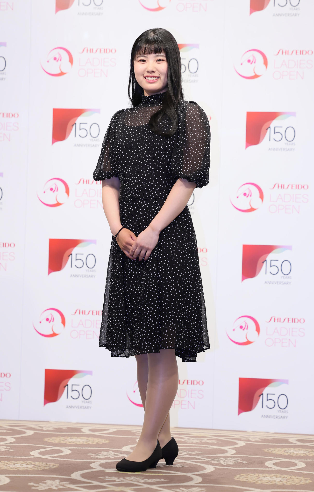 華やかにドレスアップして前夜祭に登場し、笑顔を見せる尾関（撮影・足立雅史）