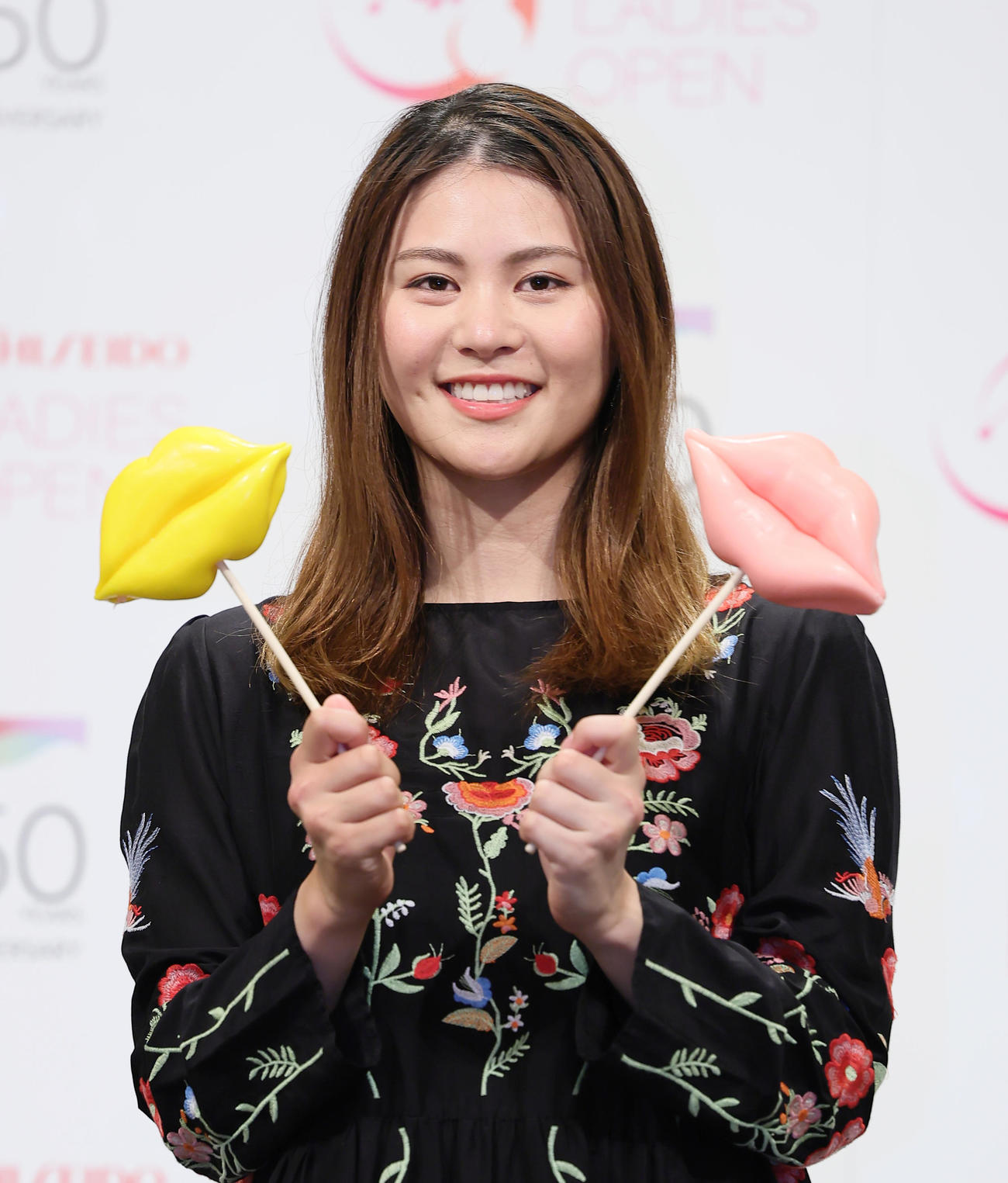 くちびる型のお菓子を手に笑顔の新垣（撮影・足立雅史）