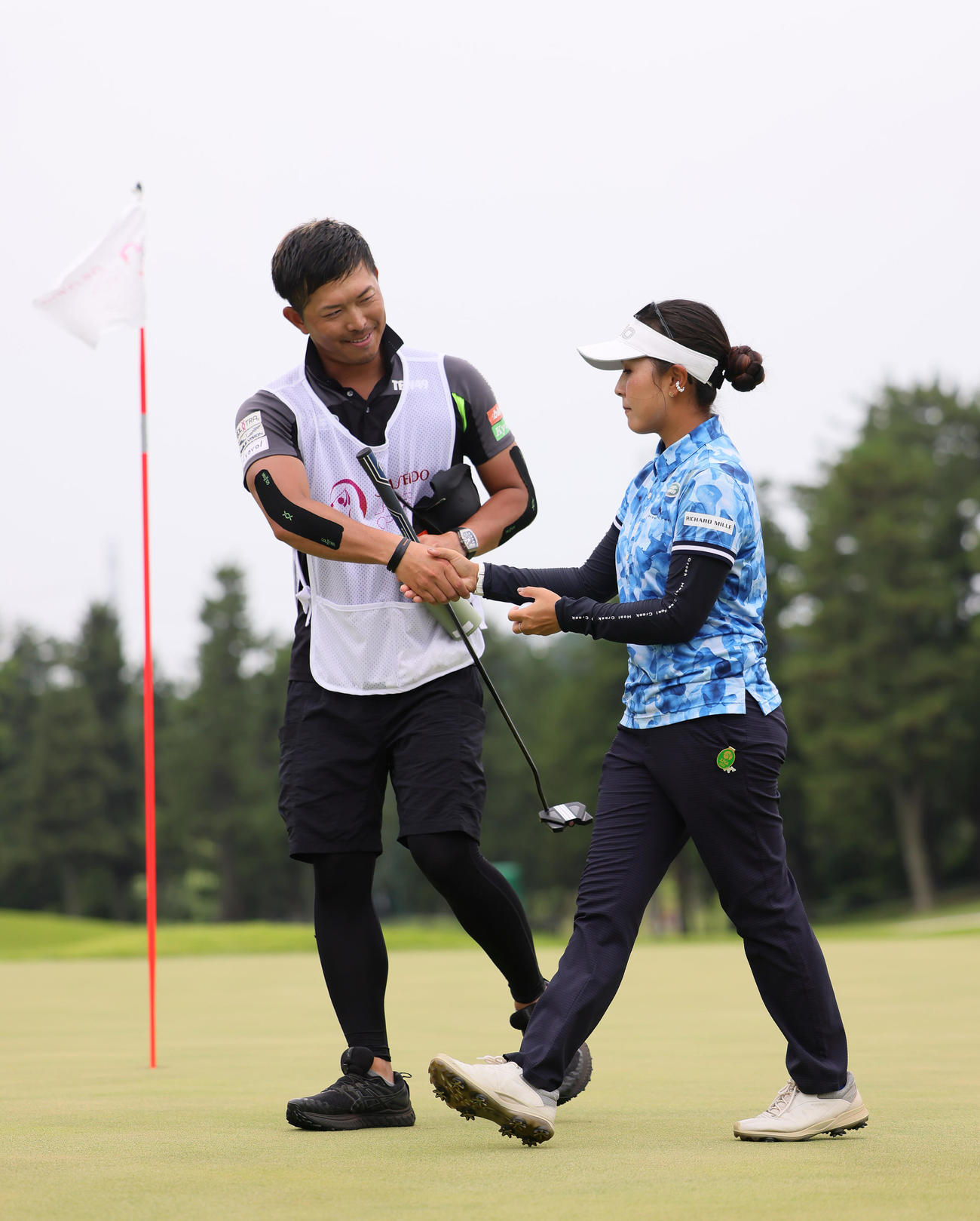 優勝を決めた青木（左）はキャディーを務めた大西コーチと握手を交わす（撮影・足立雅史）