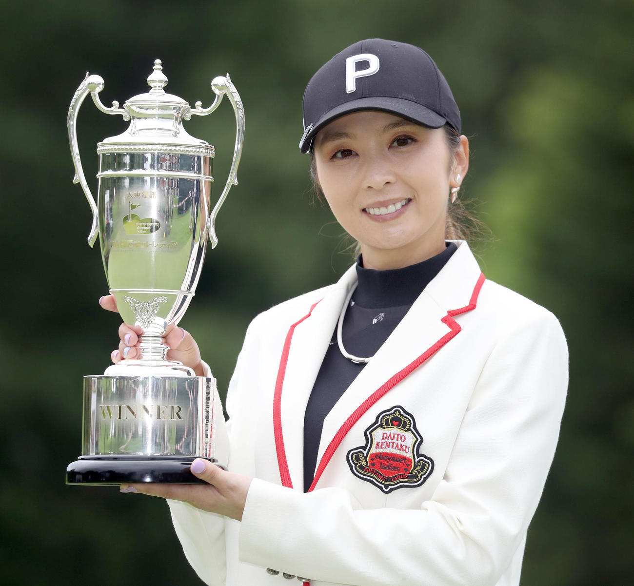 優勝杯を手に笑顔を見せる菊地（撮影・佐藤翔太）