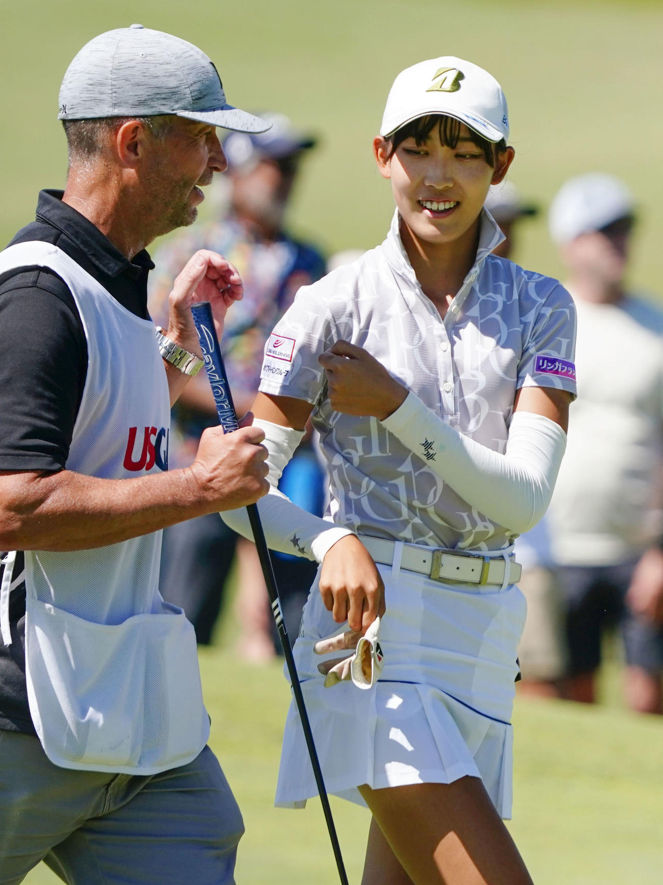 決勝の18番を終え、キャディーとタッチを交わす馬場咲希（右）（共同）