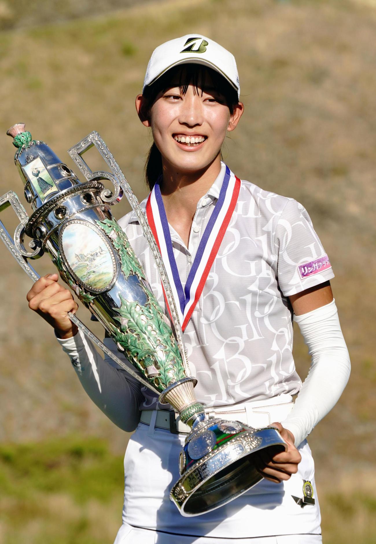 ゴルフの全米女子アマチュア選手権で日本勢として37年ぶり2人目の優勝を果たし、トロフィーを手に笑顔の馬場咲希（共同）