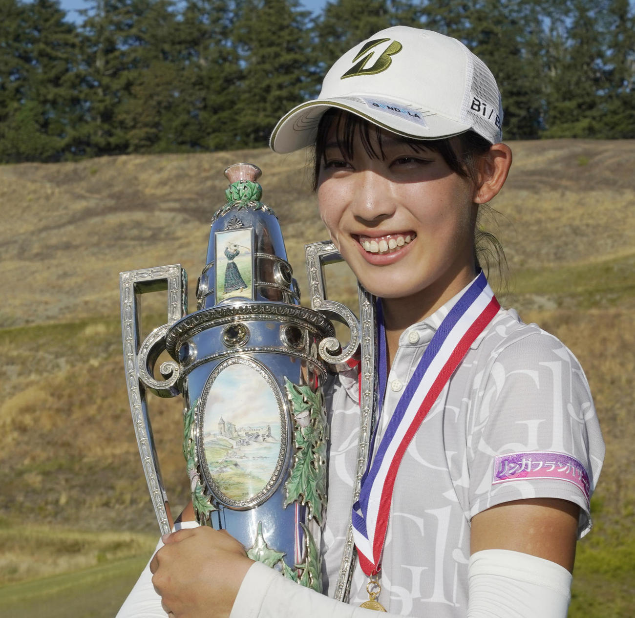 優勝トロフィーと記念撮影する馬場咲希・左袖にはリンガフランカサービス社のロゴが（AP）