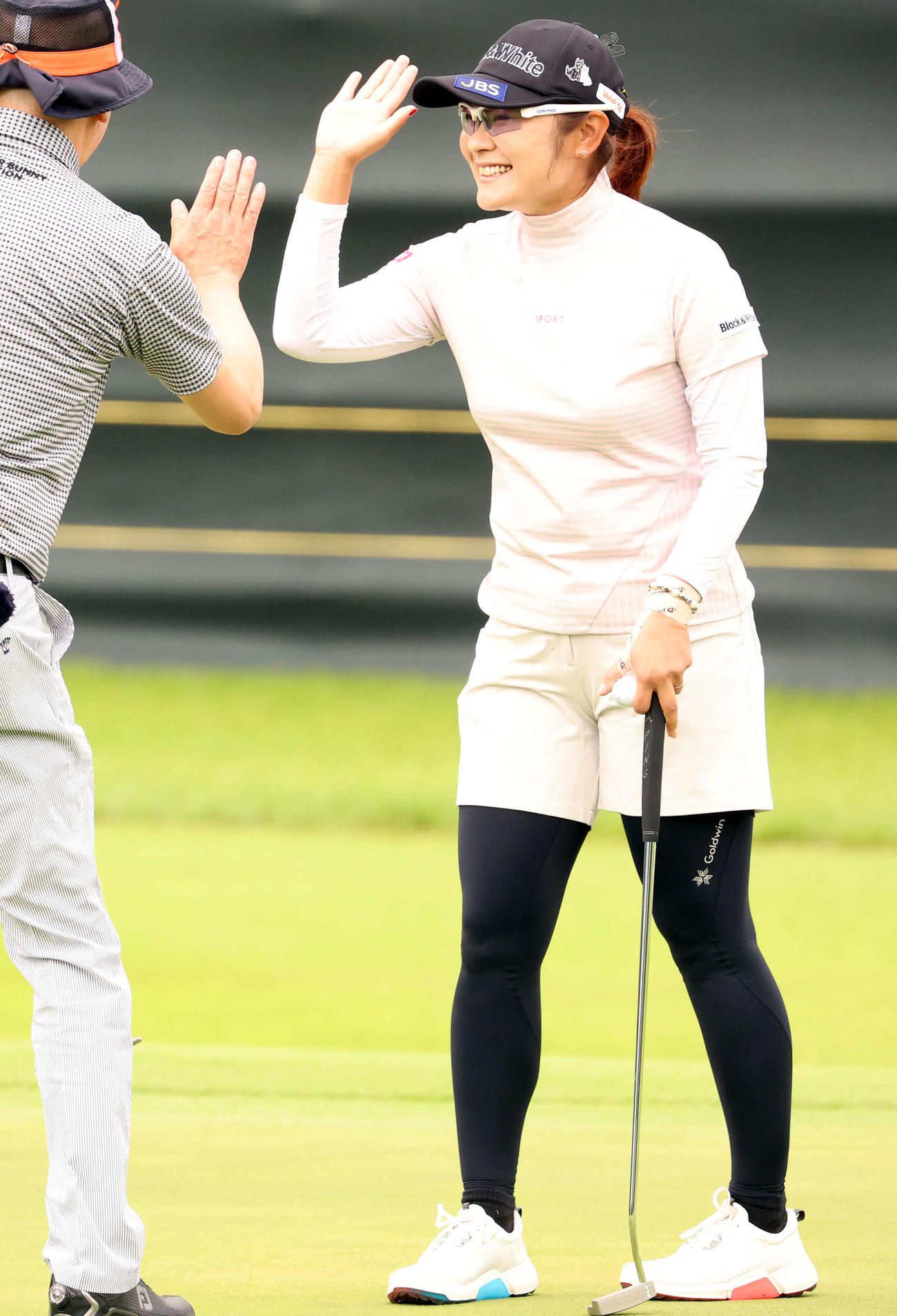 18番、パットを決めたアマ選手と笑顔でハイタッチする藤田（撮影・浅見桂子）