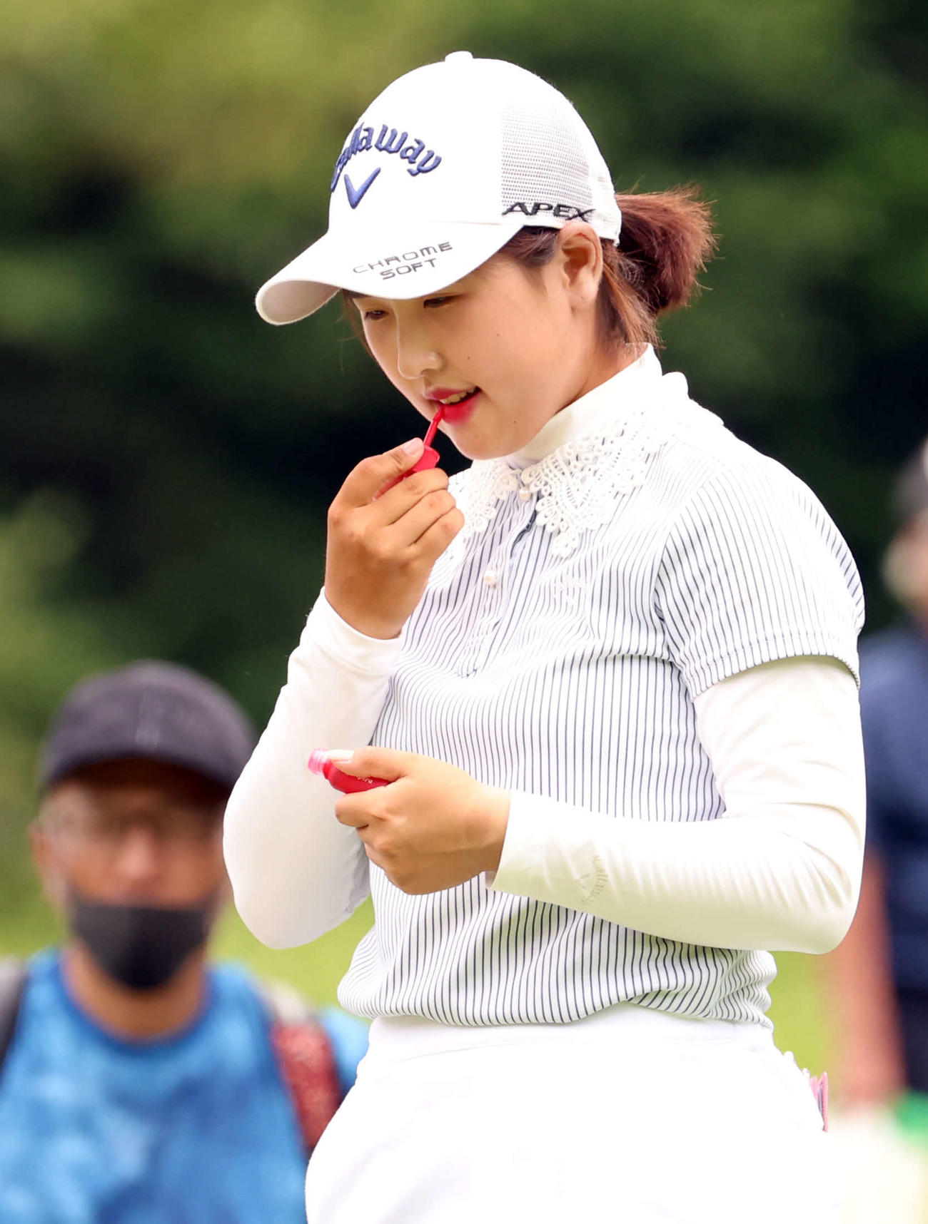 12番、ティーを待つ間、リップを塗るリ・ハナ（撮影・浅見桂子）