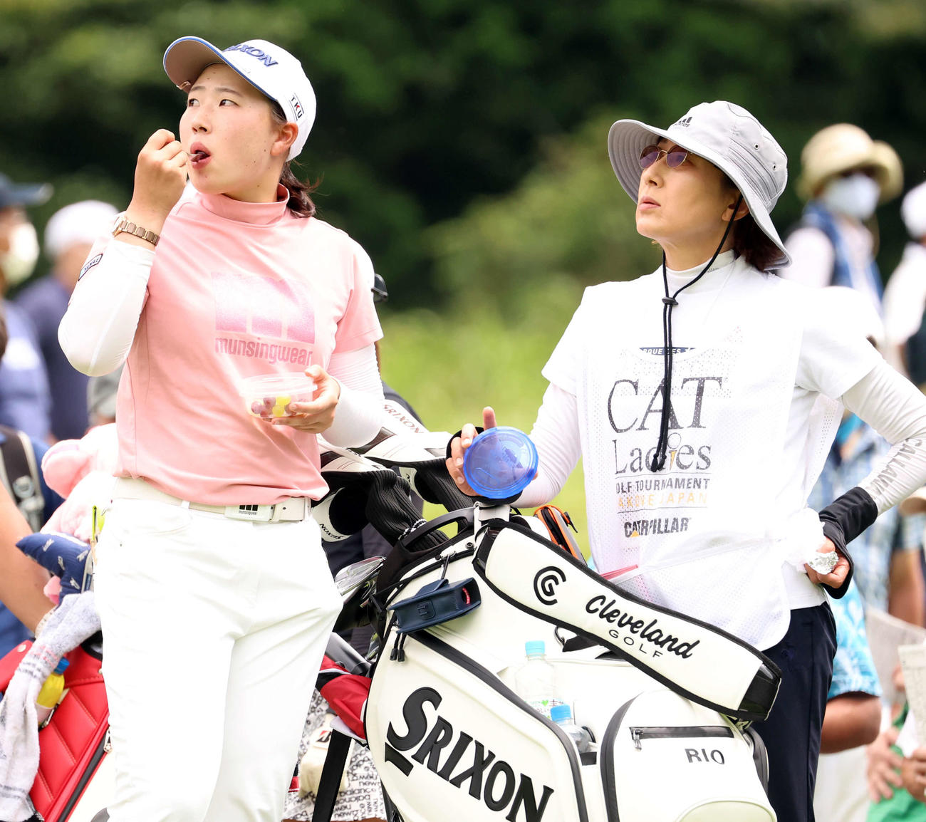 12番、ティーを待つ間、ブドウを食べる竹田。右はキャディーを務める母・哲子さん（撮影・浅見桂子）
