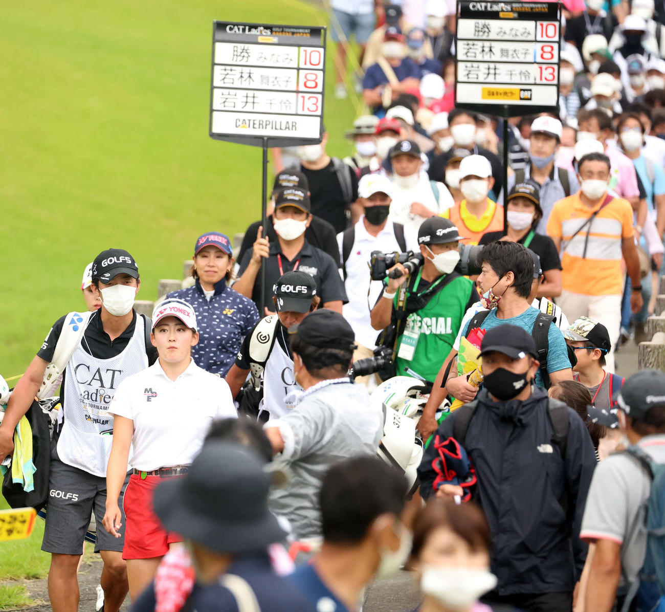 18番のティーショットを打ち終え、大勢のギャラリーと橋を渡る岩井千（左）（撮影・浅見桂子）