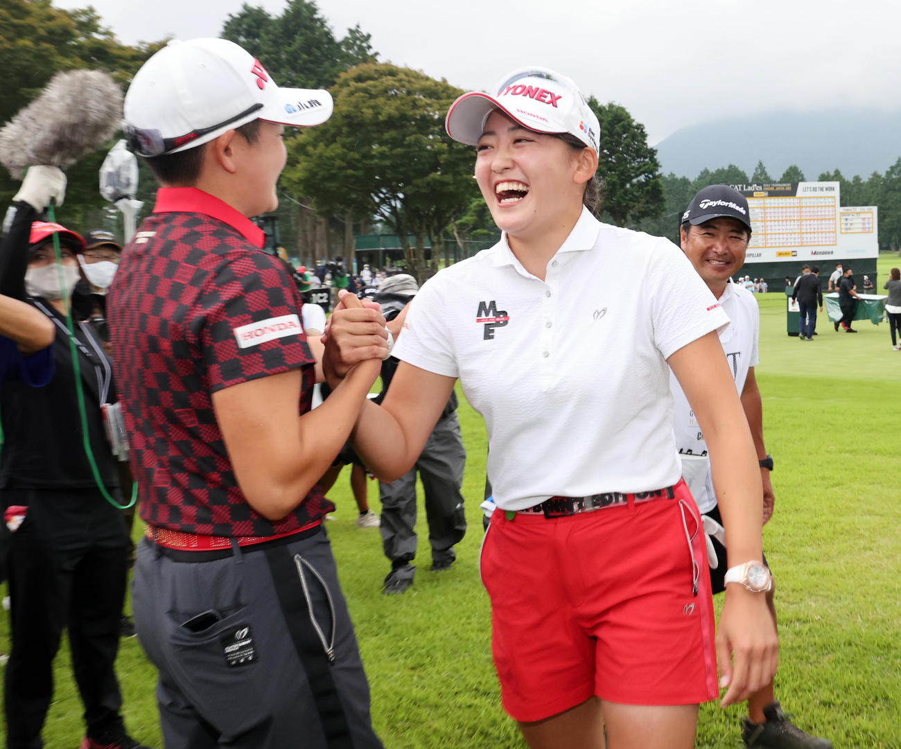 2週連続の優勝を決めた岩井千（右）は、18番グリーンで見守った姉の明愛と笑顔で握手（撮影・浅見桂子）