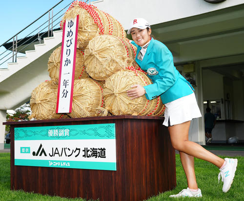 米俵の横で記念撮影する優勝の稲見（撮影・江口和貴）