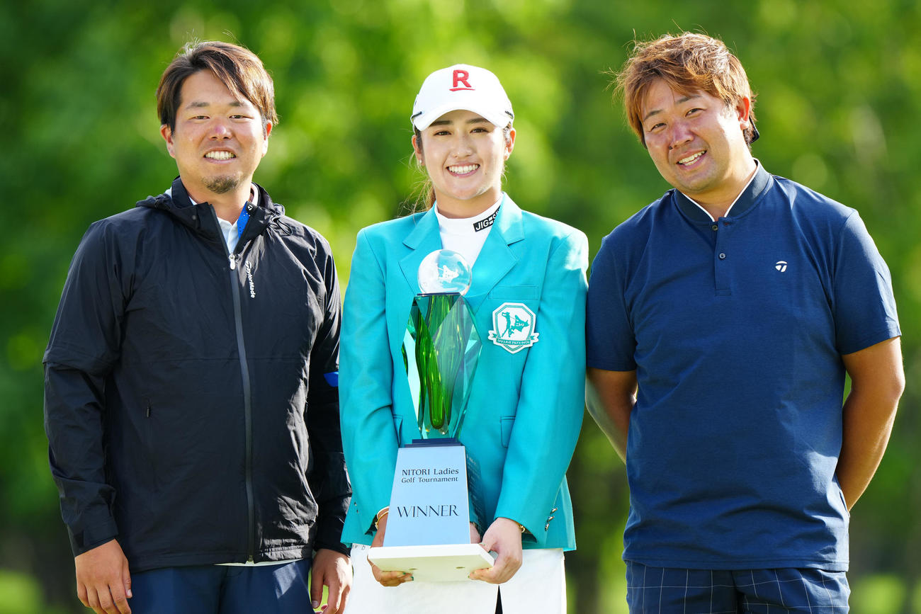 優勝カップを手に記念撮影する稲見（中央）。左は黒宮キャディー、右はパッティングコーチの橋本氏（撮影・江口和貴）