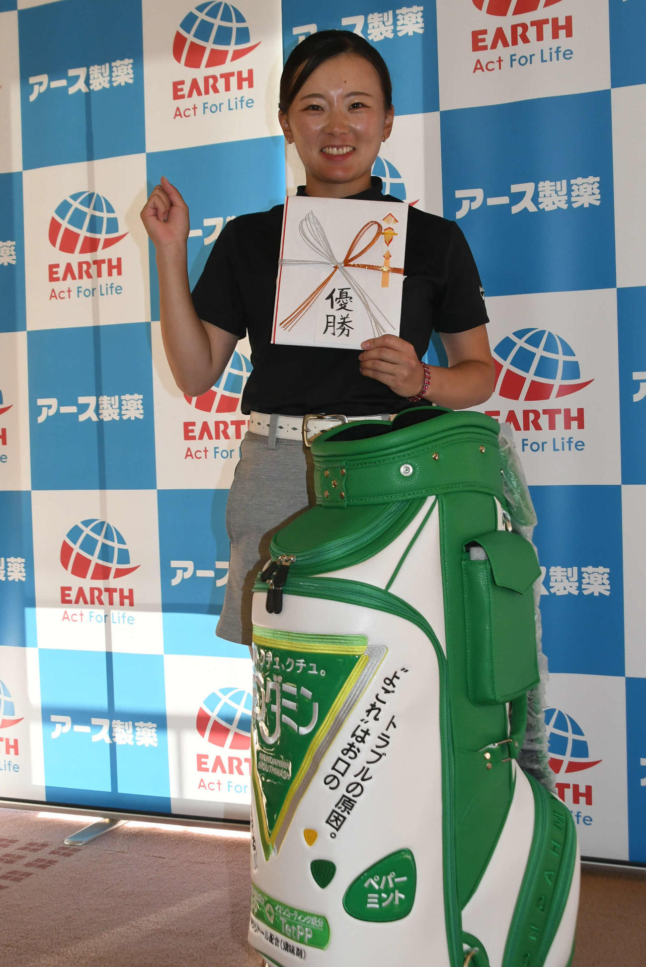 第9回TOP CONNECTレディースに優勝した円角有希は優勝賞品のモンダミン特製ゴルフバックとともににっこり