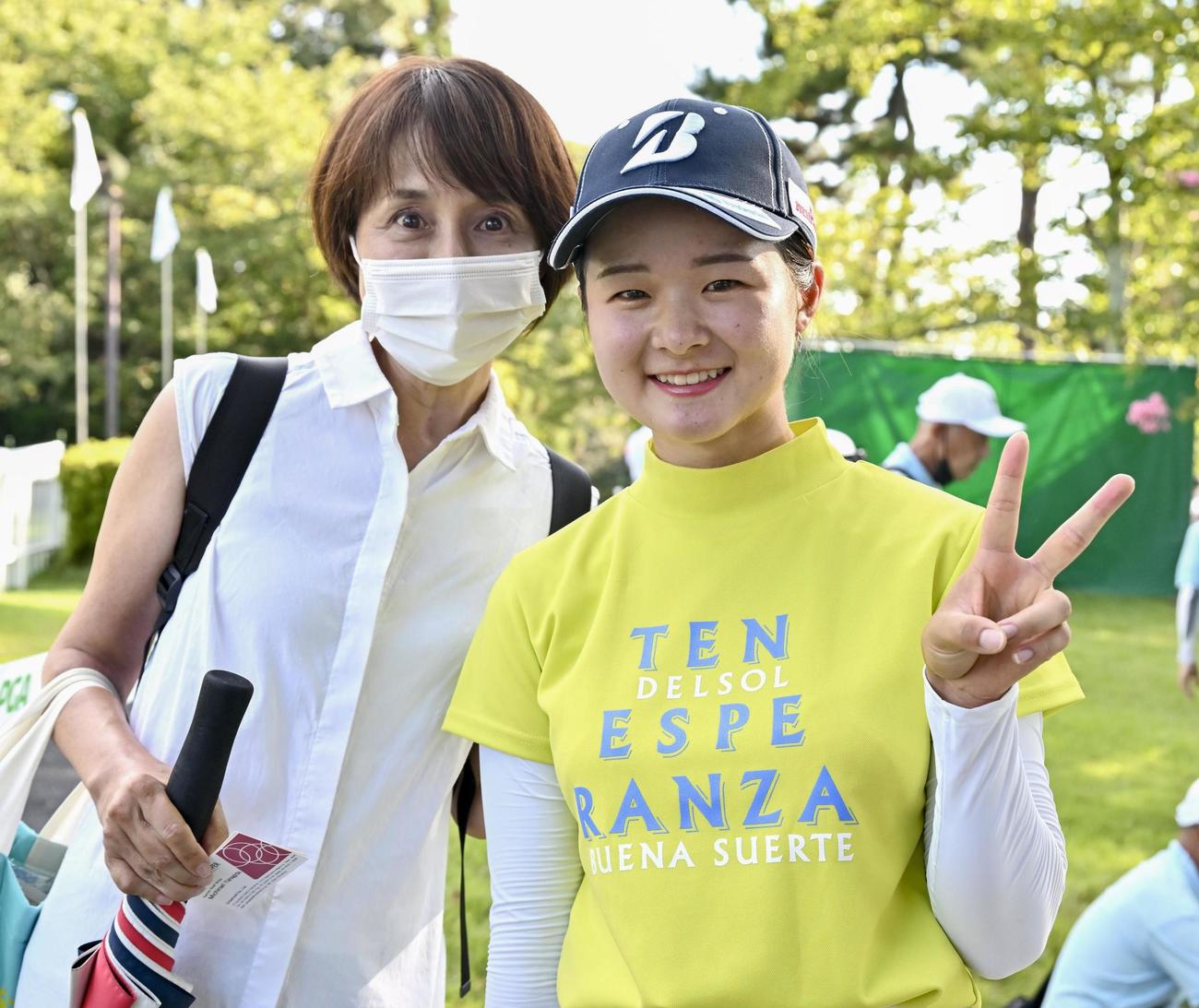 日本女子プロ選手権でツアー初優勝を果たし、笑顔で撮影に応じる川崎春花。左は母の雅子さん（共同）