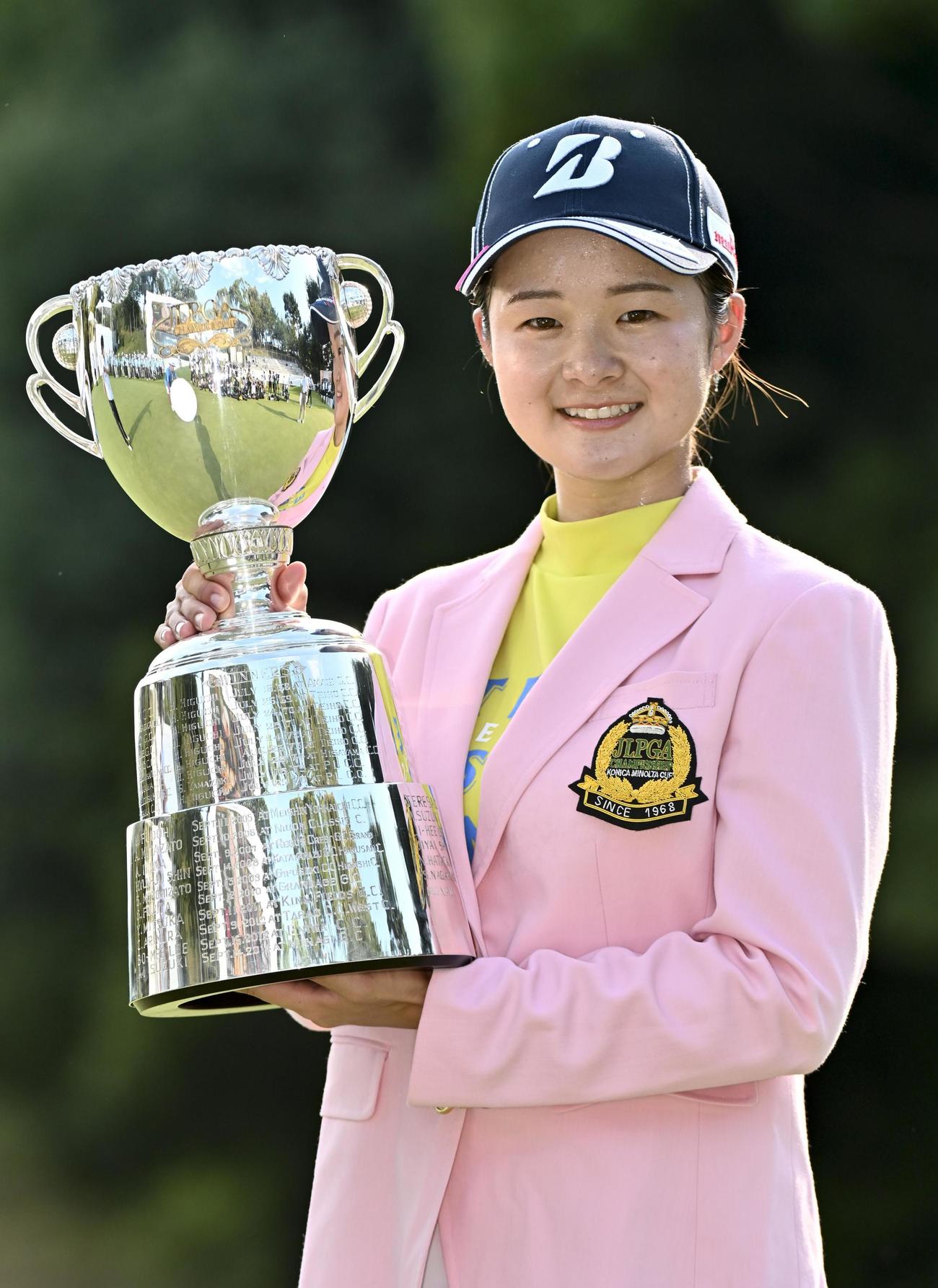 通算16アンダーで大会史上最年少優勝を果たし、カップを手に笑顔の川崎春花＝城陽CC（共同）