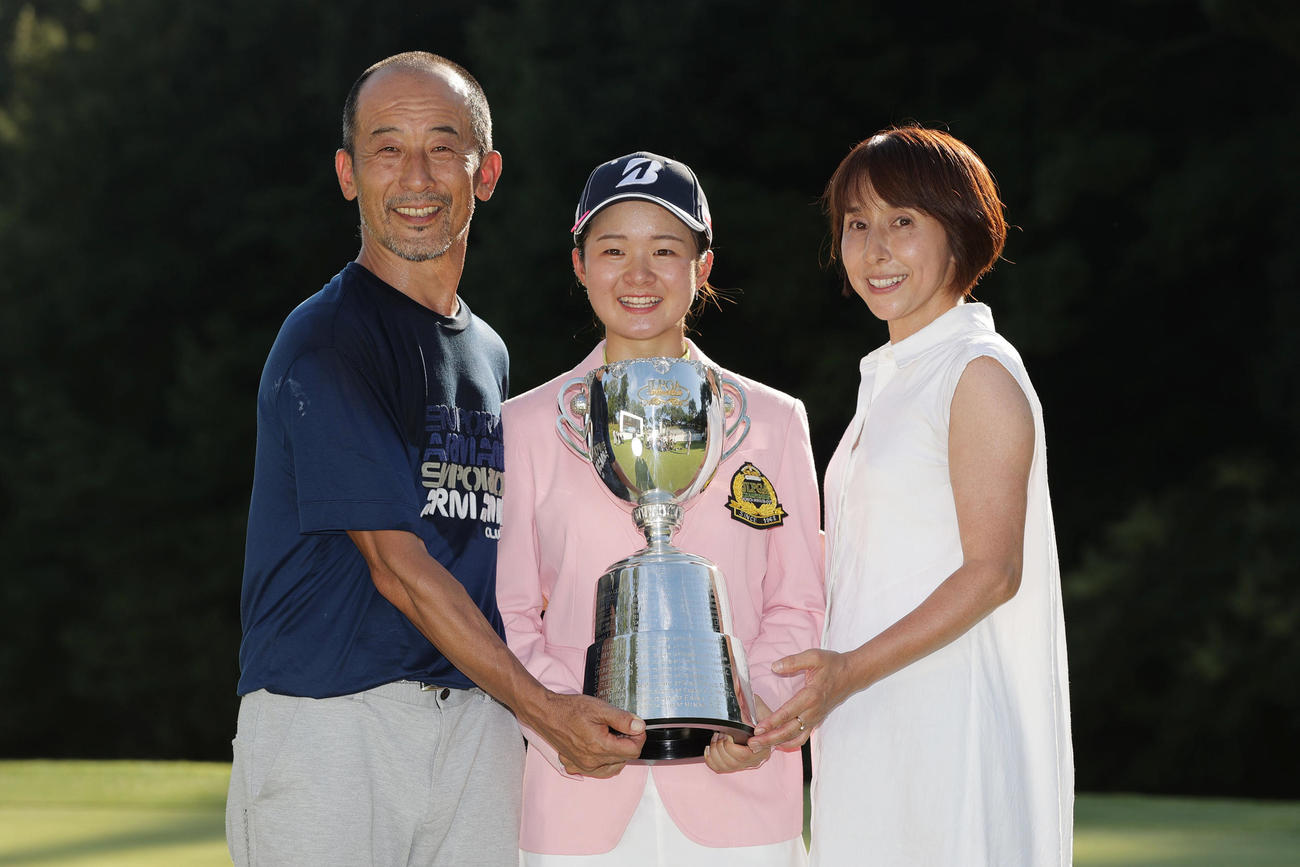初優勝を果たし、父太郎さん（左）母雅子さん（右）と笑顔で優勝トロフィーを手にする川崎（撮影・前田充）